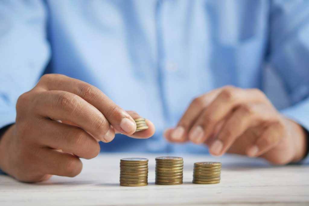 une personne qui empile des pièces de monnaie sur une table